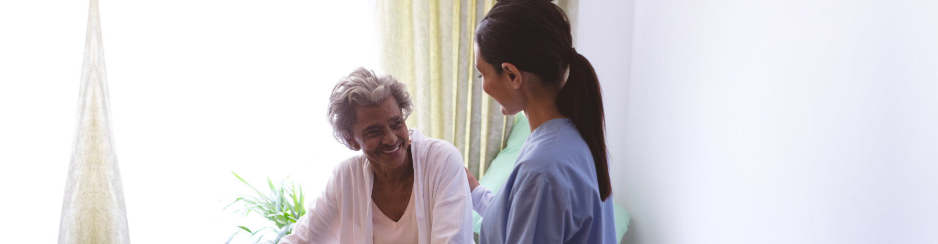 old woman smiling while facing the nurse