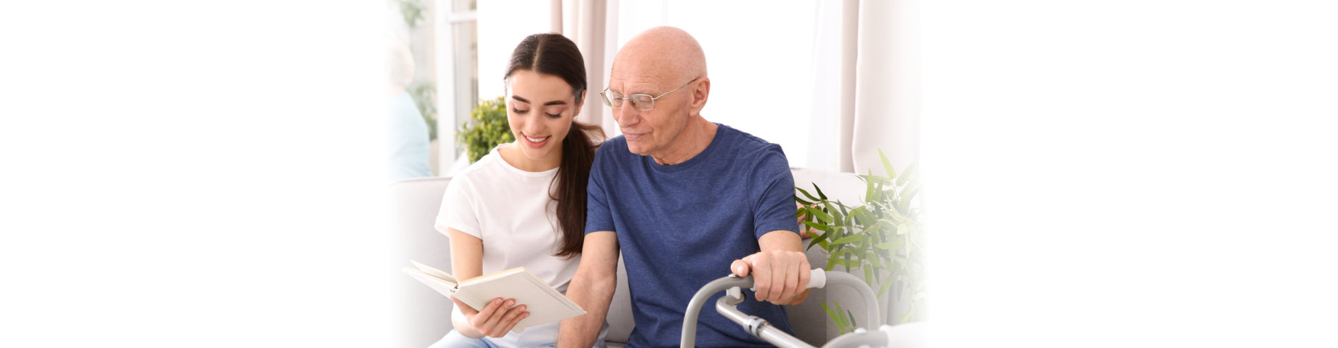young woman holding a book and teaching the old man to read or talk