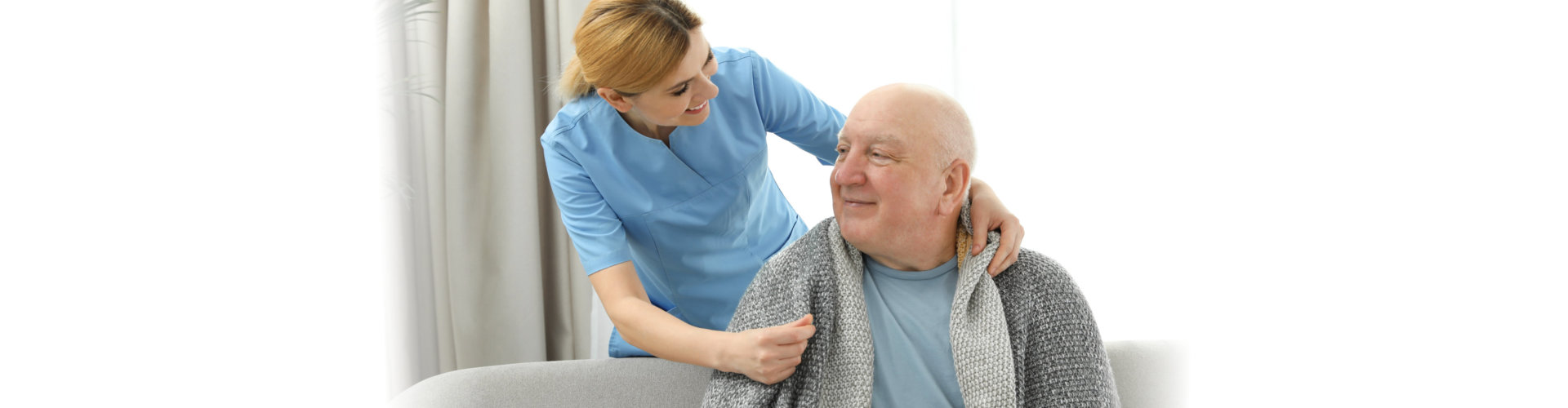 young nurse and old man smiling while facing each other